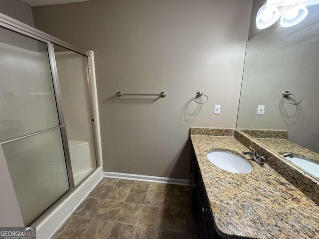 bathroom with a shower with shower door and vanity