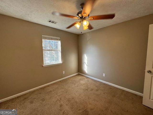 carpeted spare room with ceiling fan and a textured ceiling