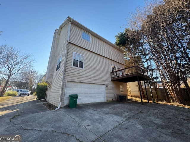 rear view of house with a wooden deck and a garage