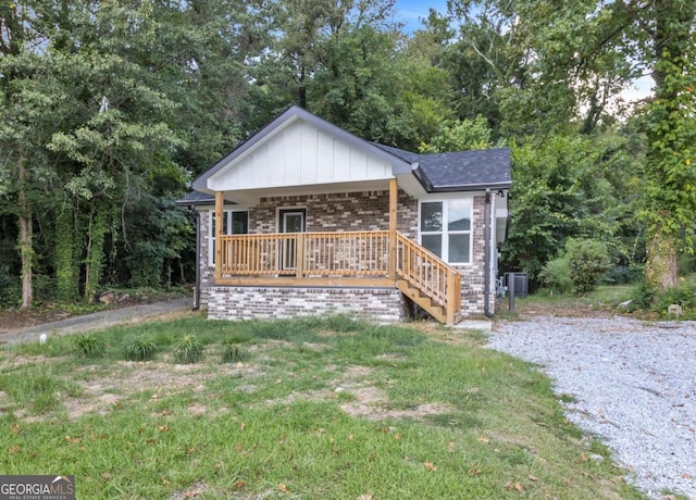 view of front facade with central AC, a front lawn, and covered porch