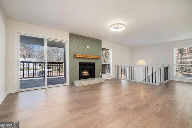 unfurnished living room featuring a fireplace and light hardwood / wood-style floors