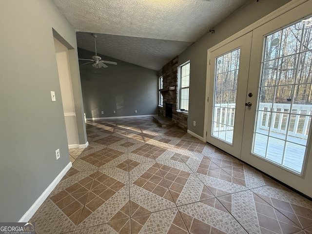 interior space with tile patterned flooring, vaulted ceiling, french doors, and a textured ceiling