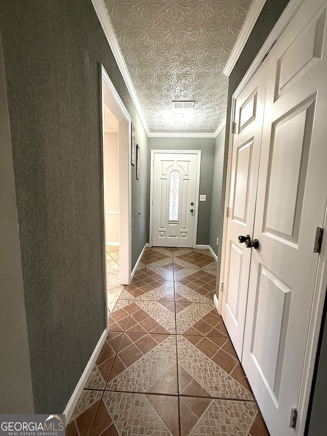 doorway to outside with crown molding and dark tile patterned flooring