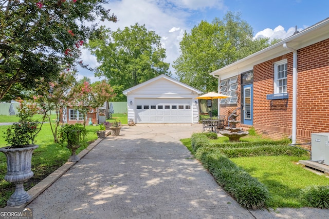 view of front facade featuring a front yard, a garage, and an outdoor structure