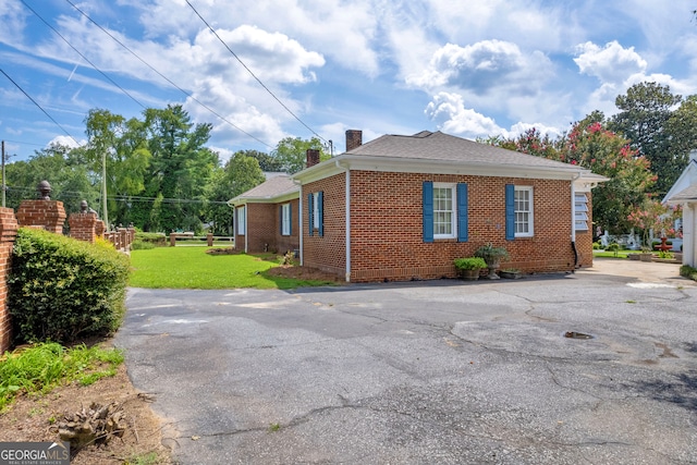 view of side of home with a lawn