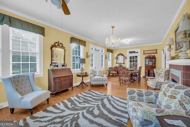 living area with a healthy amount of sunlight, light hardwood / wood-style flooring, and ornamental molding