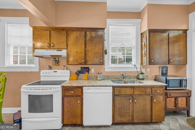 kitchen with white appliances, crown molding, and sink