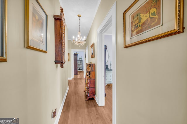 hallway featuring light hardwood / wood-style floors and a chandelier