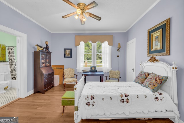 bedroom with hardwood / wood-style floors, ceiling fan, ensuite bathroom, and crown molding