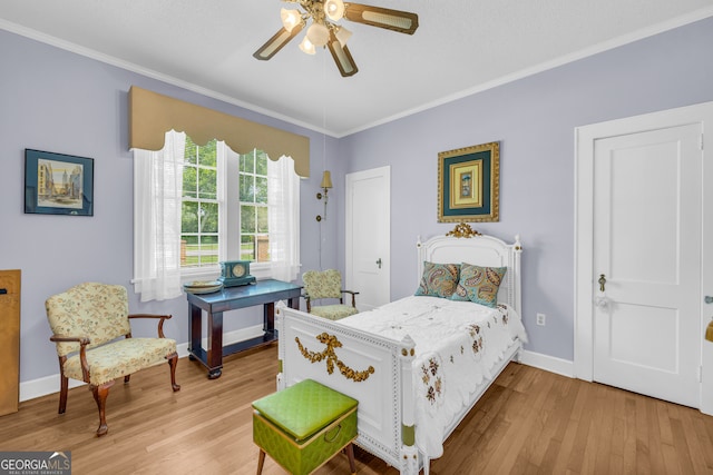 bedroom with light wood-type flooring, crown molding, and ceiling fan