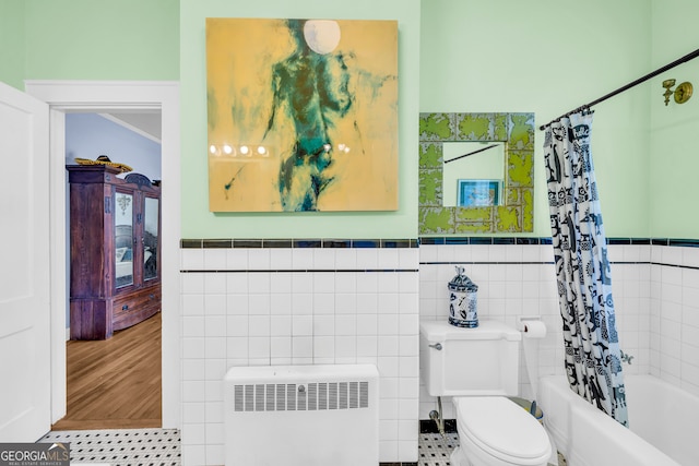 bathroom with tile walls, radiator, toilet, and shower / bath combination with curtain