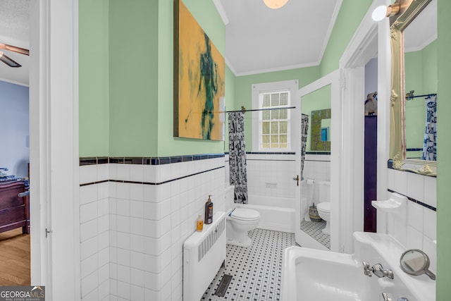 bathroom with shower / bathtub combination with curtain, radiator, ornamental molding, toilet, and tile walls