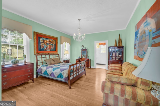 bedroom featuring ornamental molding, a notable chandelier, and light hardwood / wood-style flooring