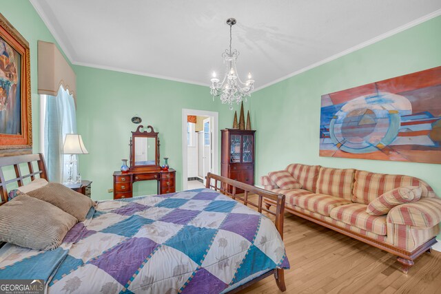 bedroom featuring ornamental molding, light wood-type flooring, and an inviting chandelier