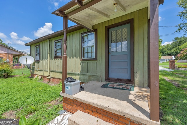 doorway to property with a lawn