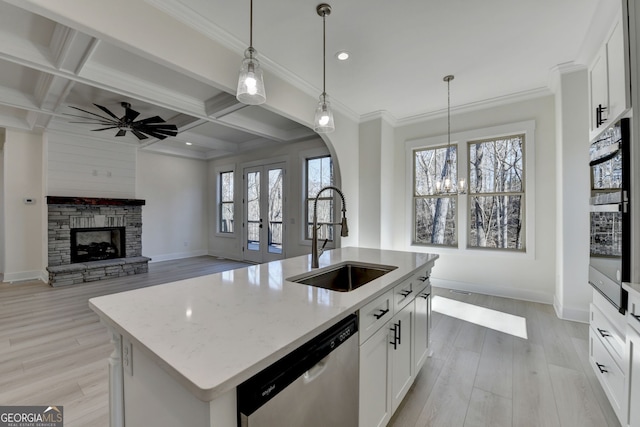 kitchen featuring pendant lighting, white cabinetry, an island with sink, sink, and stainless steel dishwasher