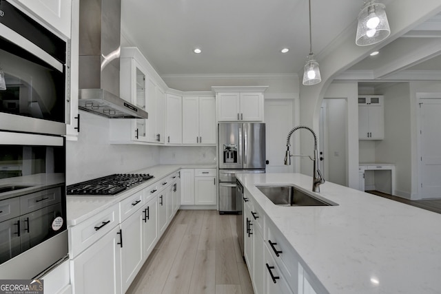 kitchen with wall chimney range hood, sink, stainless steel appliances, light stone counters, and white cabinets