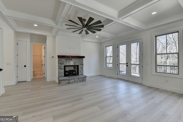 unfurnished living room with french doors, coffered ceiling, a fireplace, and light hardwood / wood-style flooring