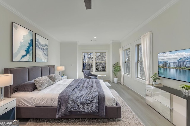 bedroom featuring ornamental molding and light hardwood / wood-style flooring