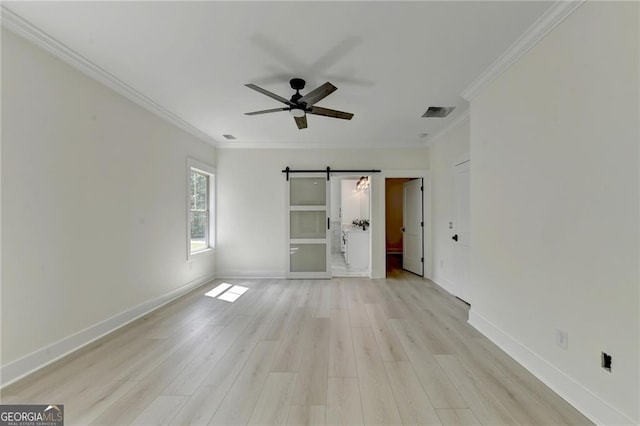 unfurnished bedroom with ornamental molding, light hardwood / wood-style floors, a barn door, and ceiling fan