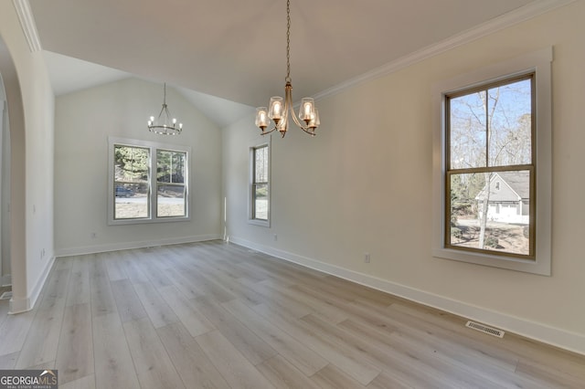 spare room featuring ornamental molding, lofted ceiling, a notable chandelier, and light hardwood / wood-style flooring