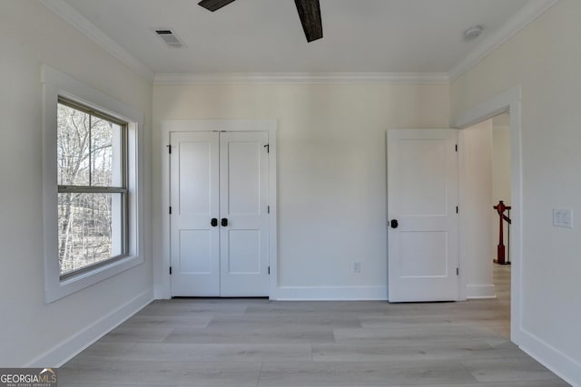 unfurnished bedroom featuring ornamental molding, ceiling fan, light hardwood / wood-style floors, and a closet