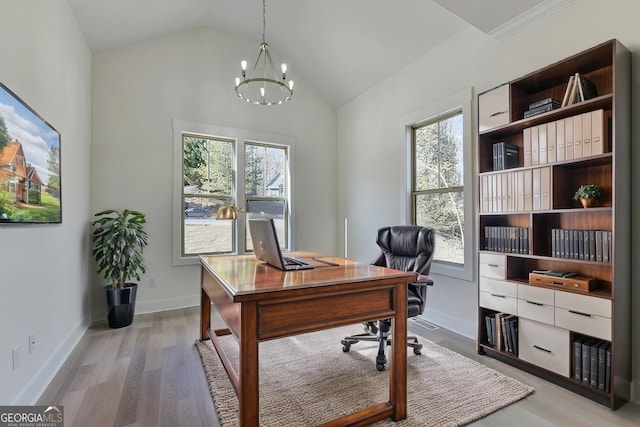 office area featuring lofted ceiling, hardwood / wood-style floors, and a chandelier