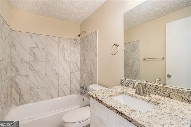 full bathroom with toilet, tiled shower / bath, vanity, and a textured ceiling