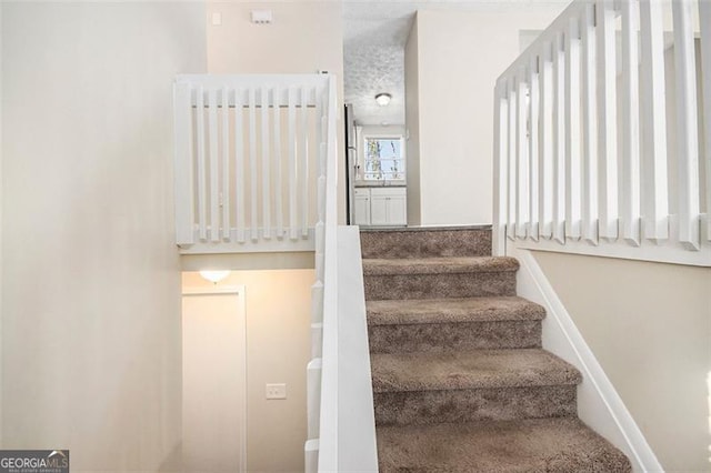 staircase with radiator and a textured ceiling