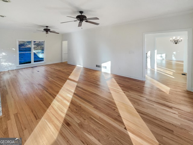 unfurnished living room with ceiling fan with notable chandelier, light hardwood / wood-style flooring, and ornamental molding