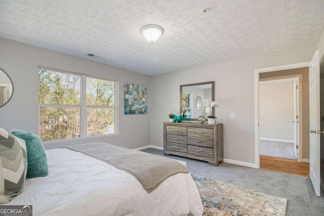 bedroom featuring light carpet and a textured ceiling