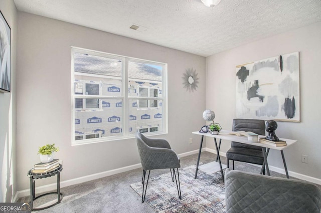 carpeted home office featuring a textured ceiling