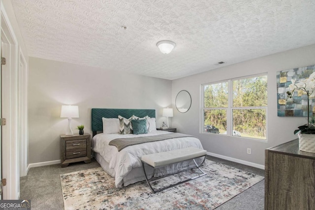 bedroom featuring a textured ceiling and light colored carpet