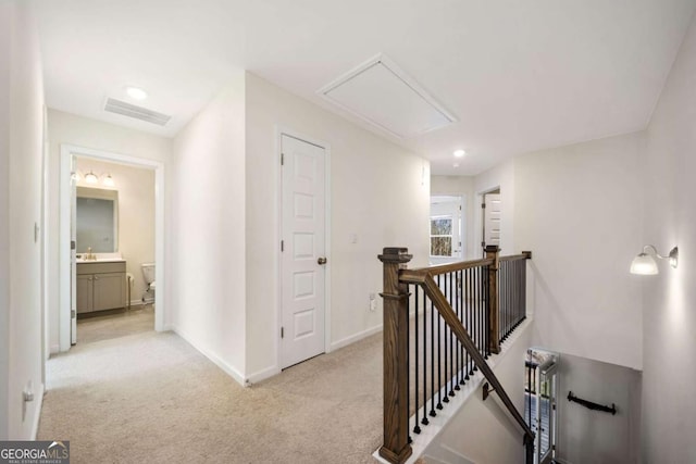 corridor featuring light colored carpet