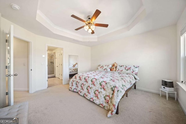 bedroom featuring ceiling fan, light colored carpet, and a tray ceiling