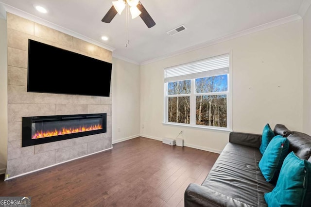 unfurnished living room featuring ceiling fan, crown molding, a fireplace, and dark hardwood / wood-style floors
