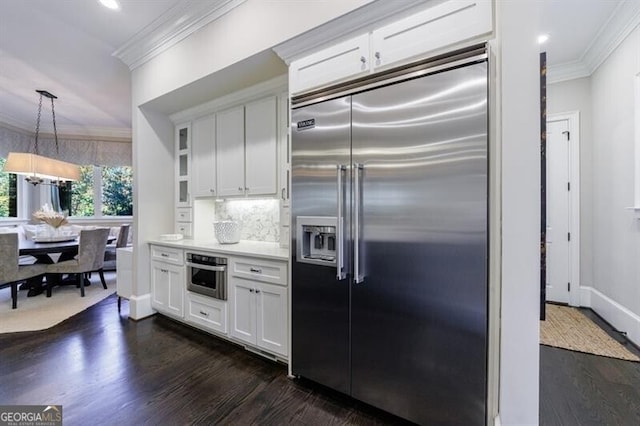 kitchen featuring white cabinetry, appliances with stainless steel finishes, backsplash, dark hardwood / wood-style flooring, and pendant lighting