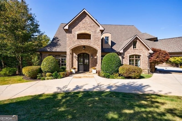 french country inspired facade with a front yard