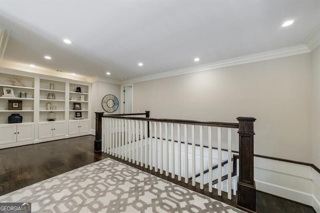 corridor featuring built in shelves, dark hardwood / wood-style floors, and crown molding