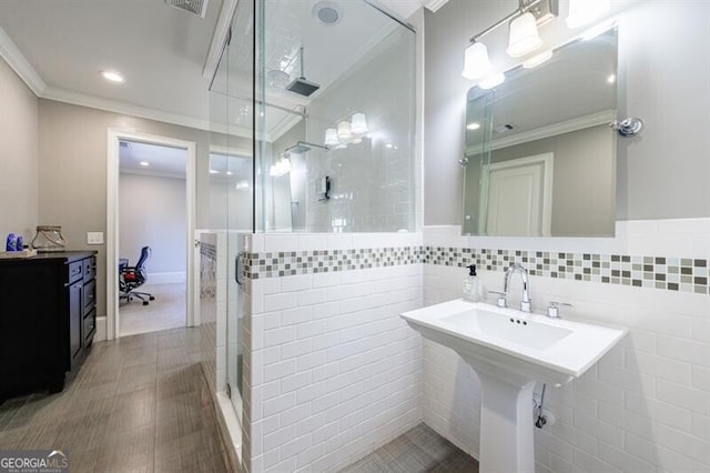 bathroom featuring sink, tile walls, an enclosed shower, and ornamental molding