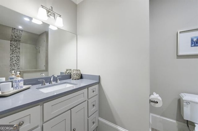 bathroom with toilet, vanity, and a tile shower