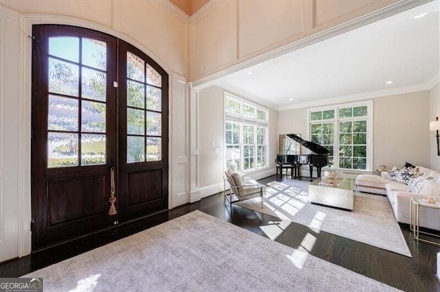 entryway featuring a wealth of natural light, dark hardwood / wood-style flooring, ornamental molding, and french doors