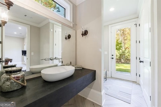 bathroom featuring toilet, ornamental molding, hardwood / wood-style floors, and sink