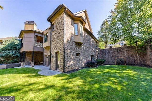 rear view of property with a patio area and a lawn