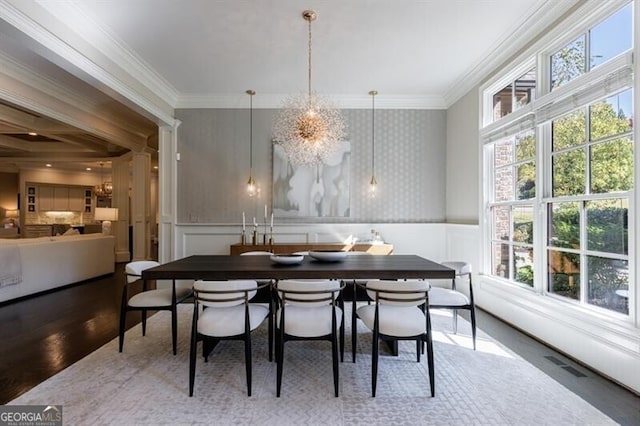 dining area with crown molding, an inviting chandelier, and hardwood / wood-style flooring