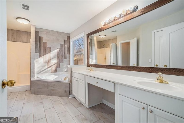 bathroom featuring vanity and independent shower and bath