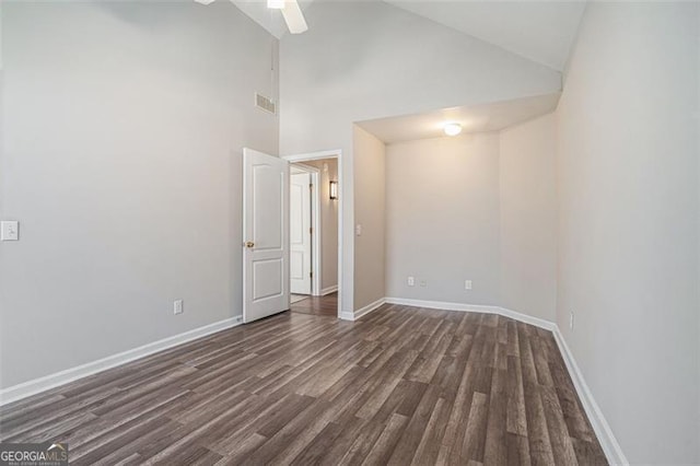 empty room featuring high vaulted ceiling, dark hardwood / wood-style floors, and ceiling fan