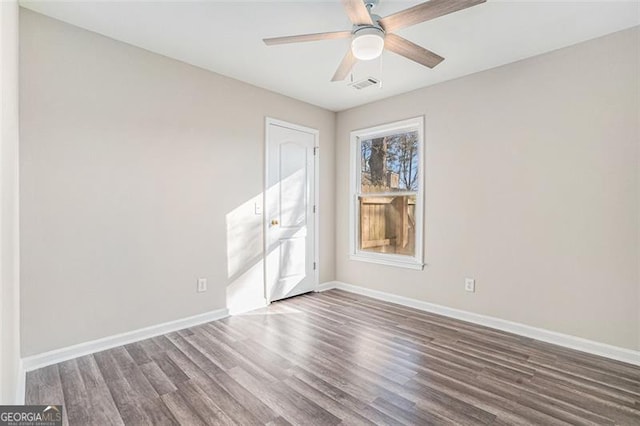 unfurnished room with ceiling fan and dark hardwood / wood-style flooring