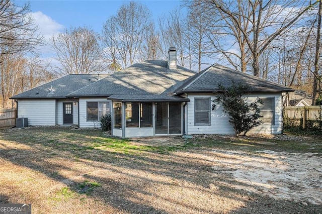 rear view of property featuring a lawn, central air condition unit, and a sunroom