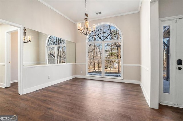 unfurnished dining area featuring crown molding, a wealth of natural light, and an inviting chandelier